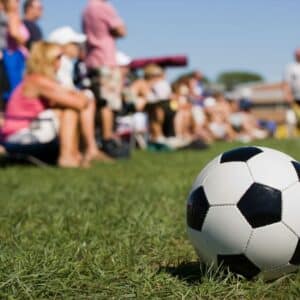 Zdjęcie przedstawiające piłkę nożna i rodziców w tle